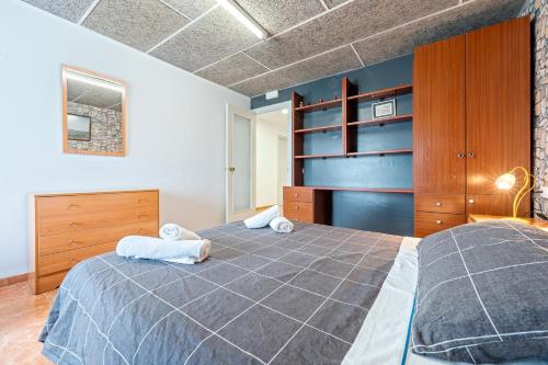 a bedroom with a large bed and wooden cabinets at Lo Perxe in Villalba dels Arcs