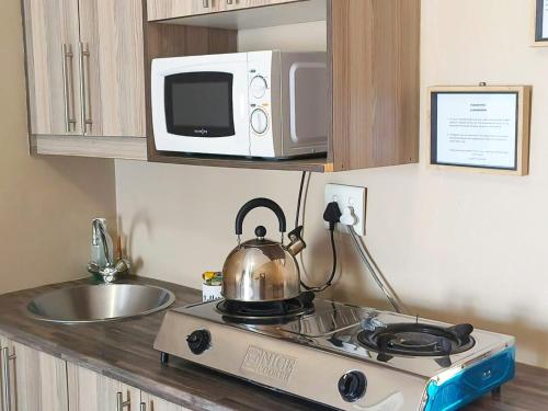 a tea kettle on a stove in a kitchen at Tokelo Guesthouse Emalahleni in Witbank