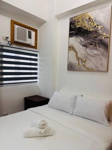 a bedroom with a white bed and a window at Serene Getaway with Prime Emperador View in Mandurriao