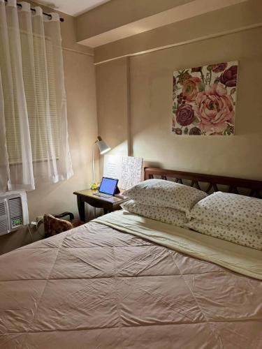 1 dormitorio con 1 cama y escritorio con ordenador portátil en East Service Road Condotels, en Manila