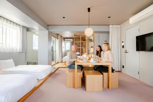 a man and woman sitting at a table in a bedroom at STAY ARI Shinjuku Takadanobaba Design awarded in Tokyo