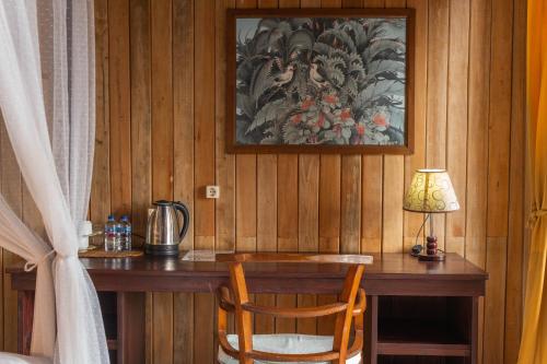 a wooden desk with a lamp and a table with a chair at Puri Alam Bali in Munduk