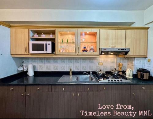 una cocina con fregadero y microondas en East Service Road Condotels, en Manila