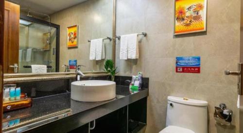 a bathroom with a toilet and a sink and a mirror at Liyuan Hotel in Shenzhen