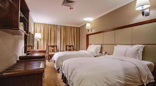 a hotel room with two beds with white sheets at Liyuan Hotel in Shenzhen