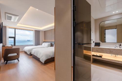 a hotel room with a bed and a bathroom at Pohang Yeongildae Beach Hotel in Pohang