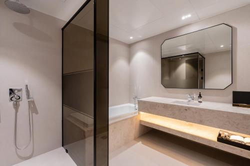 a bathroom with a shower and a sink and a mirror at Pohang Yeongildae Beach Hotel in Pohang