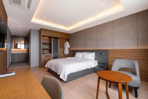 a bedroom with a bed and a table and a chair at Pohang Yeongildae Beach Hotel in Pohang