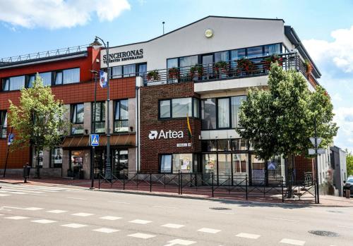 a building on the corner of a street at Hotel Sinchronas in Telšiai
