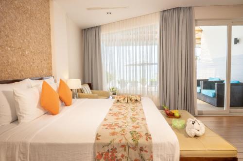 a hotel room with a bed and a large window at The Cliff Resort & Residences in Mui Ne