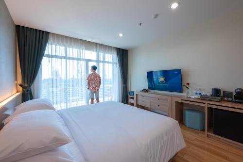 a person looking out the window of a hotel room at The Kaset, Hua Hin in Hua Hin