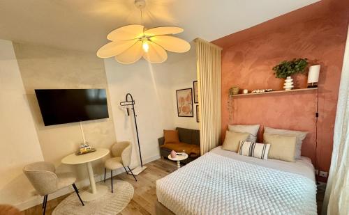 a bedroom with a bed and a ceiling fan at Le Nid du Rez in Amiens