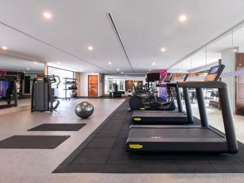 a gym with treadmills and exercise equipment in a building at Novotel Kuala Lumpur City Centre in Kuala Lumpur