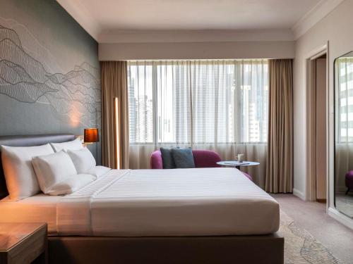 a hotel room with a bed and a large window at Novotel Kuala Lumpur City Centre in Kuala Lumpur