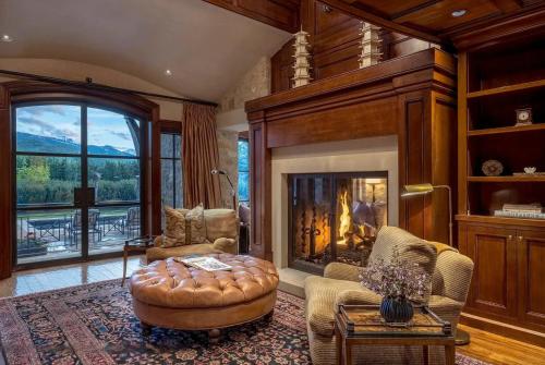 a living room with a fireplace and a chair and a table at Villa Noor in Aspen