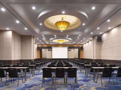 a conference room with tables and chairs and a white screen at Novotel Kuala Lumpur City Centre in Kuala Lumpur