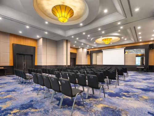 a conference room with chairs and a white screen at Novotel Kuala Lumpur City Centre in Kuala Lumpur