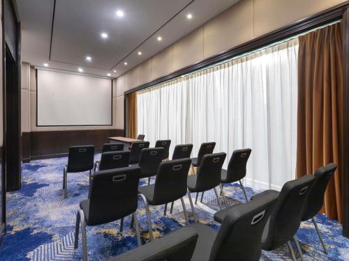 a conference room with chairs and a projection screen at Novotel Kuala Lumpur City Centre in Kuala Lumpur