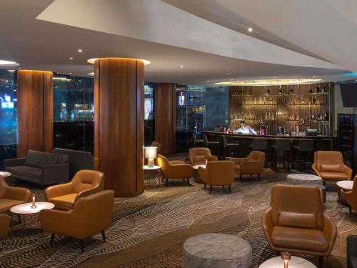 a lobby of a hotel with chairs and a bar at Novotel Kuala Lumpur City Centre in Kuala Lumpur