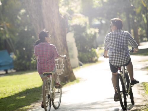 two young girls riding bikes down a path at Novotel Bali Nusa Dua in Nusa Dua