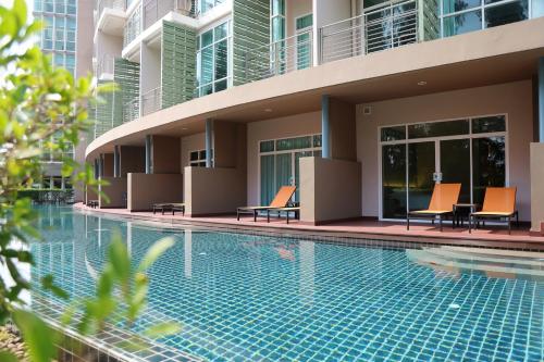 a swimming pool in front of a building at The Kaset, Hua Hin in Hua Hin