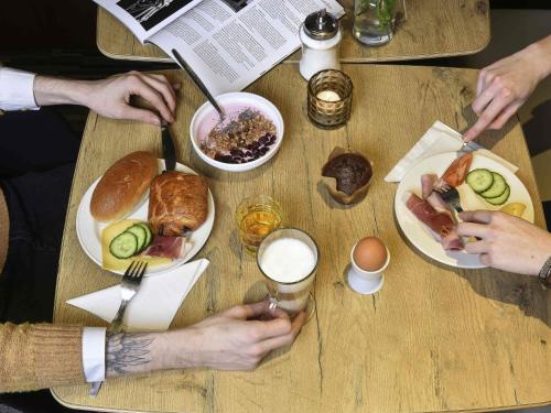 a group of people sitting at a table with plates of food at ibis Kortrijk Centrum in Kortrijk