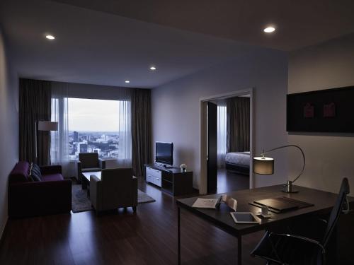 a living room with a table and a living room with a view at Pullman Kuching in Kuching