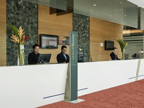 a group of men sitting at a reception desk at Pullman Kuching in Kuching