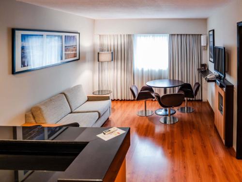 a living room with a couch and a table at Novotel Lima San Isidro in Lima