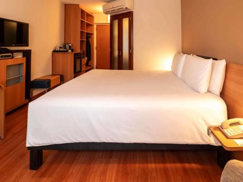 a large white bed in a hotel room at Novotel Lima San Isidro in Lima