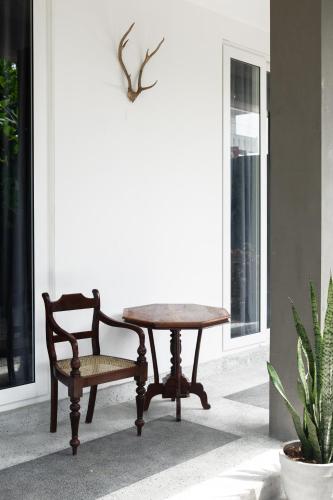 a wooden table and a chair sitting next to a table at Buddy's Place in Ambalangoda