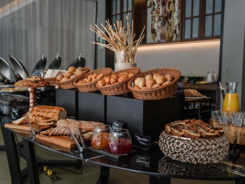 a table topped with baskets of bread and pastries at Novotel Lima San Isidro in Lima