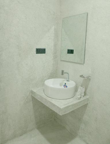 a white bathroom with a sink and a mirror at Buddy's Place in Ambalangoda