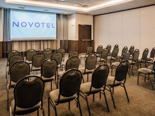 a conference room with rows of chairs in front of a screen at Novotel Lima San Isidro in Lima