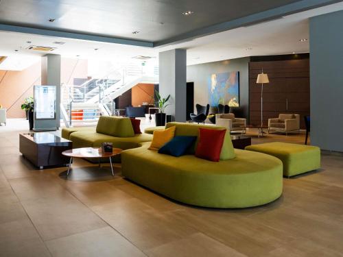 a living room with two couches and a table at Novotel Lima San Isidro in Lima