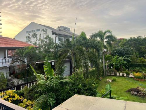 a view of a garden with palm trees and a house at Sea Breeze Guest House Negombo in Negombo