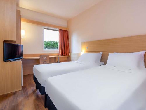 Ένα ή περισσότερα κρεβάτια σε δωμάτιο στο ibis Campo Grande