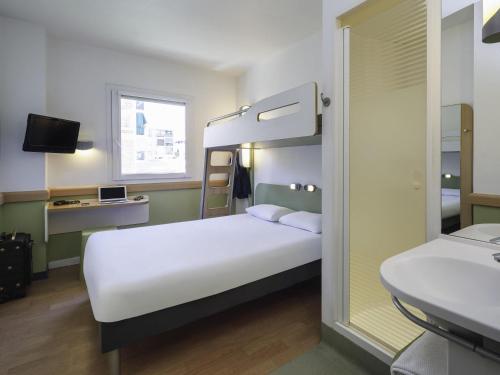a bedroom with a bed and a bunk bed at Ibis Budget Málaga Centro in Málaga