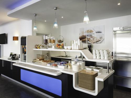 a kitchen with a counter with some food on it at Ibis Budget Málaga Centro in Málaga
