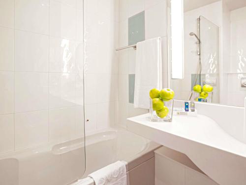 a white bathroom with a sink and a shower at Novotel Salerno Est Arechi in Salerno