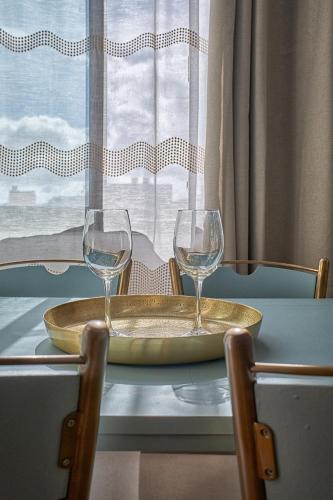two wine glasses sitting on a table next to a window at Casa Amaore La Gomera in Playa de Santiago