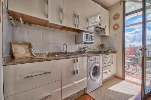 a kitchen with a sink and a washing machine at Casa Amaore La Gomera in Playa de Santiago