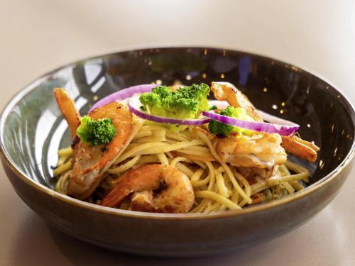 a bowl filled with pasta with shrimp and broccoli at Mercure Paris Ivry Quai De Seine in Ivry-sur-Seine