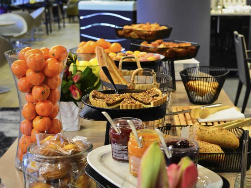a table topped with plates of food and snacks at Mercure Paris Ivry Quai De Seine in Ivry-sur-Seine