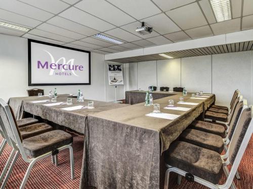 a large conference room with a long table and chairs at Mercure Paris Ivry Quai De Seine in Ivry-sur-Seine