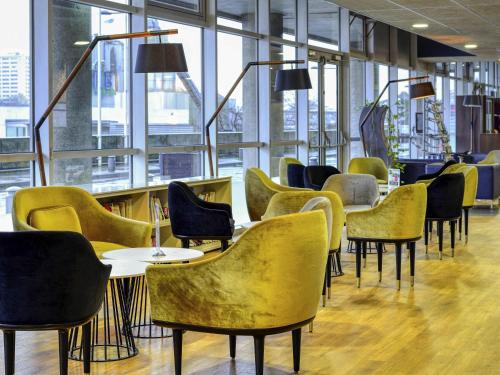 a row of chairs and tables in a room with windows at Mercure Paris Ivry Quai De Seine in Ivry-sur-Seine