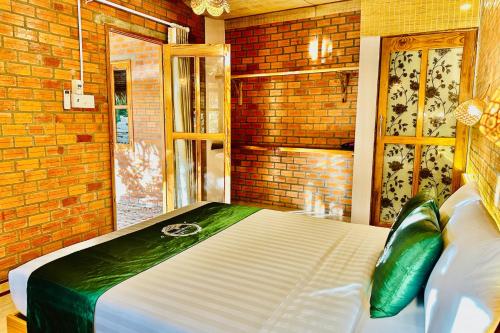 a bed in a room with a brick wall at Mekong Rustic Riverside in Ấp An Nhơn (3)
