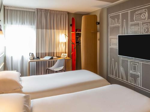 a hotel room with two beds and a chalkboard wall at ibis Birmingham Airport Terminal Building - NEC in Bickenhill