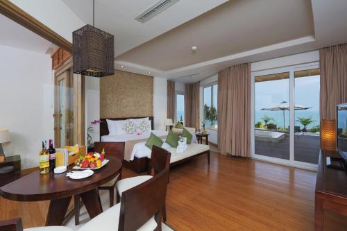 a living room with a table and a dining room at The Cliff Resort & Residences in Mui Ne