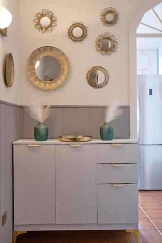 a kitchen with white cabinets and mirrors on the wall at Casa Amaore La Gomera in Playa de Santiago